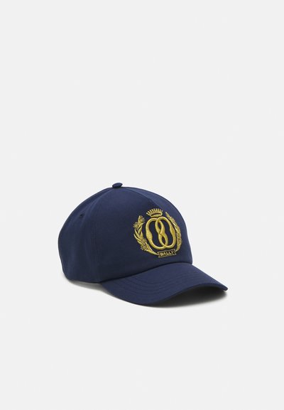 Tumesinine baseballi müts, mis on valmistatud kangast ja millel on kõver serv. Esiküljel on kuldne tikandiga logo ja laurel aktsendid.