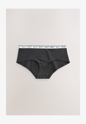 Crne pamučne gaćice s bijelim elastičnim pojasom na kojem piše "NEXT." Glatka tekstura s dizajnom pune pokrivenosti bez vidljivih uzoraka ili naglasaka.
