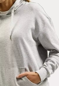 Szary hoodie wykonany z miękkiego materiału, z przednią kieszenią, kapturem na sznurki i minimalnym logo. Gładka tekstura i luźny krój.