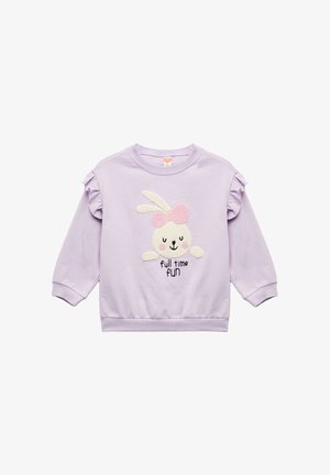 Liliowa bluza z falbankami na rękawach, z pluszowym białym królikiem w różowej kokardzie oraz napisem "pełnoetatowa zabawa" w czerni poniżej.