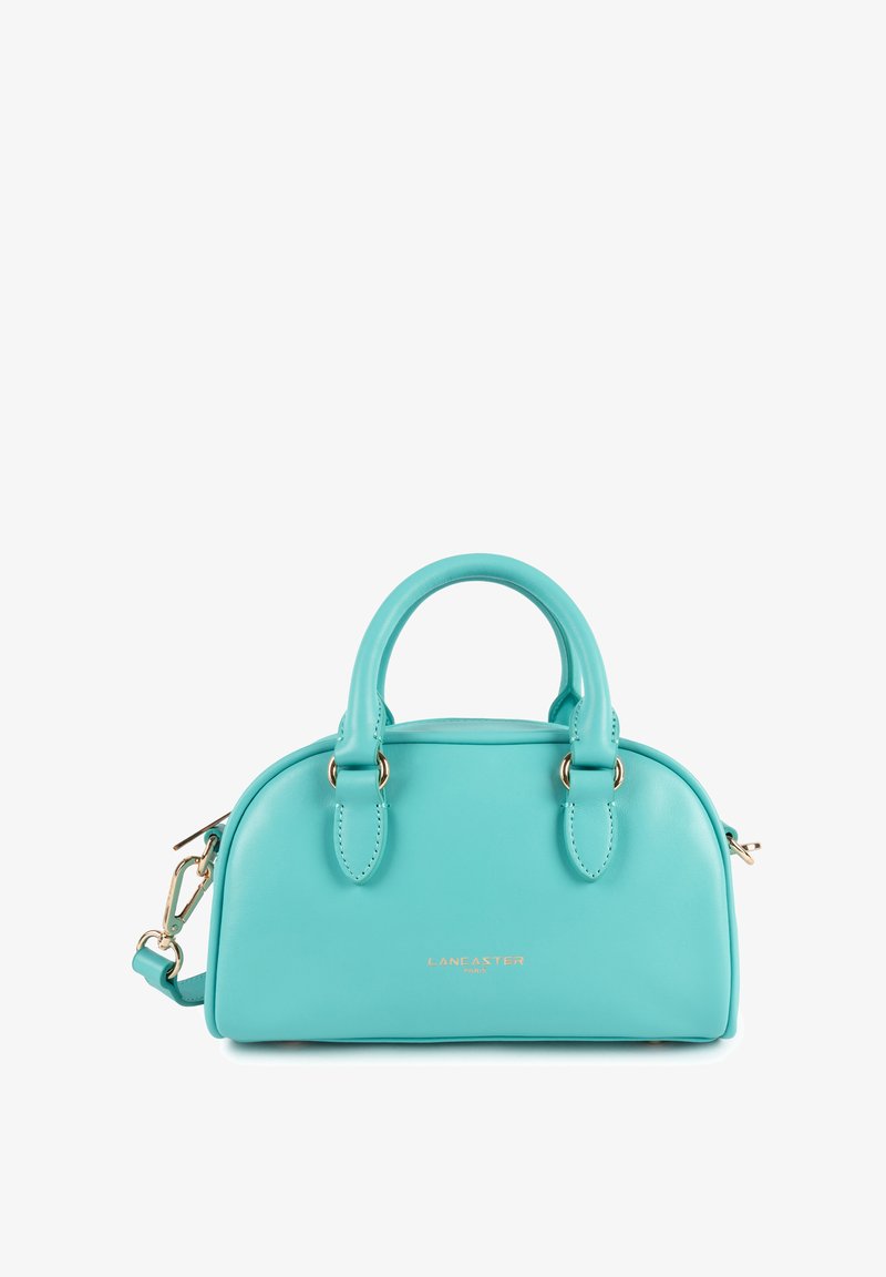Sac à main en cuir turquoise avec une forme arrondie, double anses supérieures, bandoulière amovible, logo doré et texture lisse.