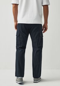 Herren Cargo-Shorts in Navy mit zwei Seitentaschen und lässigem Schnitt. Hergestellt aus Baumwollstoff, mit glatter Textur und geradem Bein.