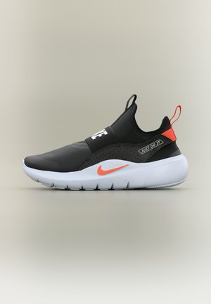 Chaussure de sport noire et orange à enfiler avec semelle blanche, logo Nike swoosh, et texte "Just Do It" sur le côté et la sangle avant.