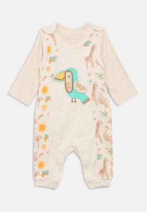 Lys beige barneheldress med lange ermer, med et sentralt motiv av en tukan og mønstrede sider med dyr og solmotiver.