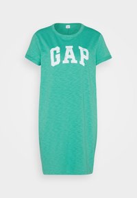 Grünes Baumwoll-T-Shirt-Kleid mit Rundhalsausschnitt, kurzen Ärmeln und dem weißen "GAP"-Logo, das auf der Vorderseite zentriert ist. Weiche Textur und lässiger Schnitt.