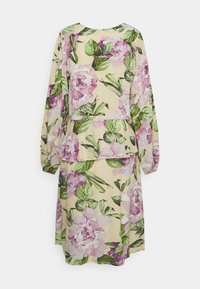 Vestido floral com mangas longas; apresenta padrões de peónias em rosa pastel e verde sobre um fundo bege; design de cintura peplum e textura suave.