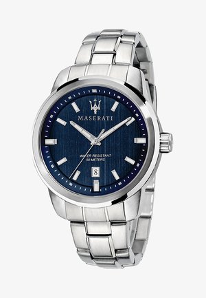 Montre Maserati avec un cadran texturé bleu, un boîtier en acier inoxydable argenté, des marqueurs horaires numériques et un affichage de la date à 6 heures. Étanche jusqu'à 50 mètres.