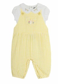Dzeltena gingham rompre ar baltu apkakli, divām priekšējām pogām un ziedu izšuvumu uz kabatas. Mīksts, viegls kokvilnas audums.