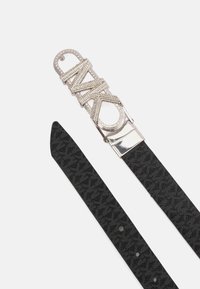 Zwarte stoffen riem met een reliëflogo-patroon, voorzien van een glanzende zilveren gesp versierd met een ontwerp met strassteentjes waarin "NAKD" staat.