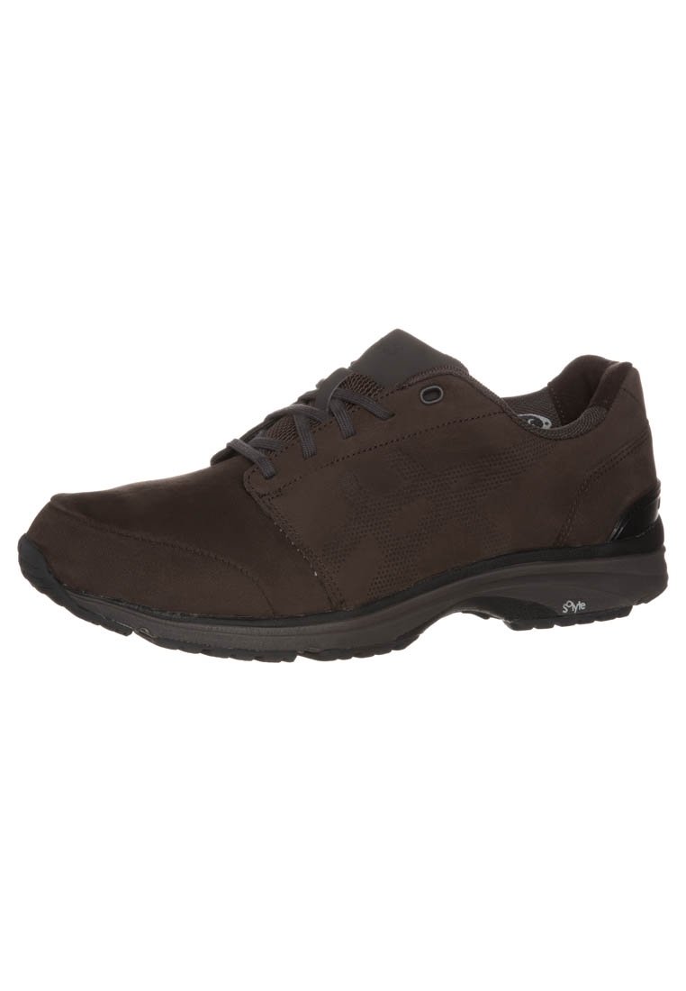 Scarpa sportiva marrone con superiore liscio e testurizzato, chiusura con lacci e suola imbottita. Presenta un piccolo logo sul lato e accenti sottili.