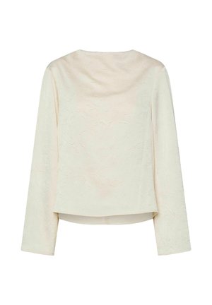 Krémový top s dlouhými rukávy, vyrobený z texturované tkaniny a s volným výstřihem. Spodek je zkrácený s mírným poklesem vzadu.