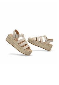 Sandalias de cuña con un upper de ante beige claro, que presentan cuatro correas anchas y una correa en el tobillo con hebilla, montadas sobre una suela de plataforma cubierta de yute texturizado.