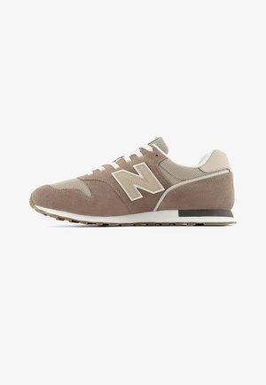 Zapatilla New Balance beige y marrón claro con paneles de ante y malla, cordones blancos, suela acolchada y suela de goma con dibujo, vista lateral.