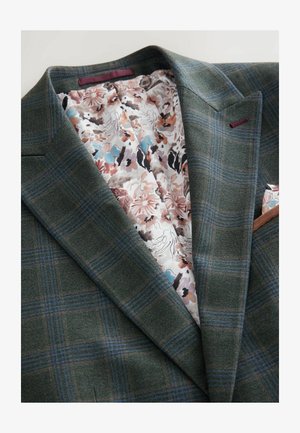 Grüner karierten Blazer mit einer strukturierten Wolloberfläche. Gefüttert mit floral bedrucktem Stoff, der rosa, blau und schwarze Akzente aufweist.