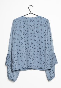 Hellblaue Bluse mit einem floralen Muster in Dunkelblau. Lange Ärmeln mit gerafften Manschetten, rundem Ausschnitt und einem leichten High-Low-Saum.