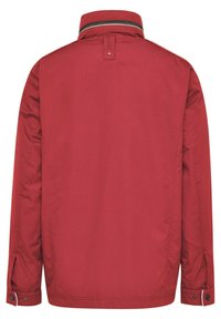 Red jacket with a straight cut, high collar, and contrast stitching. Features buttoned cuffs and a smooth fabric texture. Minimalist design.