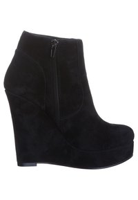 Botines de ante negros con cuña y plataforma delantera, y cremallera lateral; textura suave, punta redondeada y diseño contorneado.