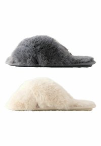 Two pairs of plush slippers: one gray and one cream. Both have a soft, fuzzy texture, open design, and flat rubber soles.