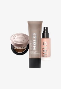 Trois produits de soin Smashbox Halo : un compact rond avec un couvercle métallique, un tube beige avec du texte argenté et un flacon spray transparent.