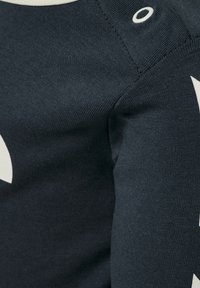 Mörk marinblå tröja med en strukturerad finish, med en stor grafisk detalj i off-white. Accentuerad med en cirkulär detalj vid axelsömmen.