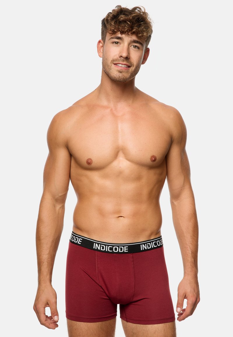 Mörkröda boxershorts i stretchigt material, med en svart midja som har "INDICODE"-logotyp. Fitted design med slät yta.
