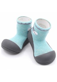 Botitas de punto azules con suelas de goma gris. Presentan una suela texturizada, una parte superior tipo calcetín y un diseño simple de cara de animal en el costado.