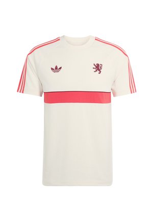 Camiseta blanca de Adidas con una franja horizontal roja, tres rayas rojas en las mangas y los logotipos de Adidas y un león en color granate en el pecho.