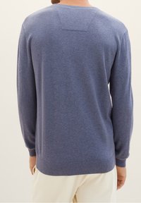 Niebieski dziergany sweter z okrągłym dekoltem, długimi rękawami, ściągaczami przy mankietach i u dołu, o gładkiej fakturze i minimalistycznym wzornictwie.