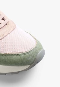 Sneaker featuring a pink mesh upper, beige suede accents, and a textured green suede toe cap. Gray rubber sole with a rounded edge.