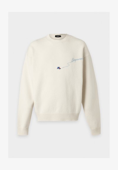 Pull en maille couleur crème avec poignets et ourlet côtelés, orné de petits oiseaux brodés bleu et rouge et d'un texte en cursive bleu clair sur la poitrine.