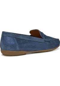 Niebieskie zamszowe buty wsuwane z zaokrąglonym noskiem, kontrastującą, tanową gumową podeszwą oraz dekoracyjnym przeszyciem wzdłuż boku dla dodatkowego detalu.