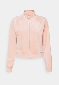 Veste zippée en velours rose clair avec col montant, manches longues, poignets élastiques, deux poches avant zippées et un petit logo brodé sur la poitrine.