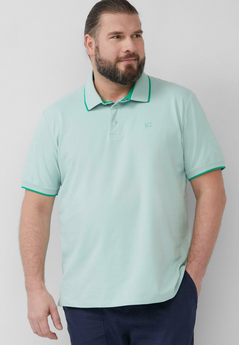 Licht groene polo met een kraag en groene accenten. Korte mouwen, zachte textuur, met een klein logo op de borst. Casual fit.