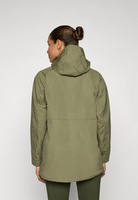 Olijfgroene hooded jack met een rechte snit en lange mouwen, voorzien van een rugpand en een iets langere zoom aan de achterkant.