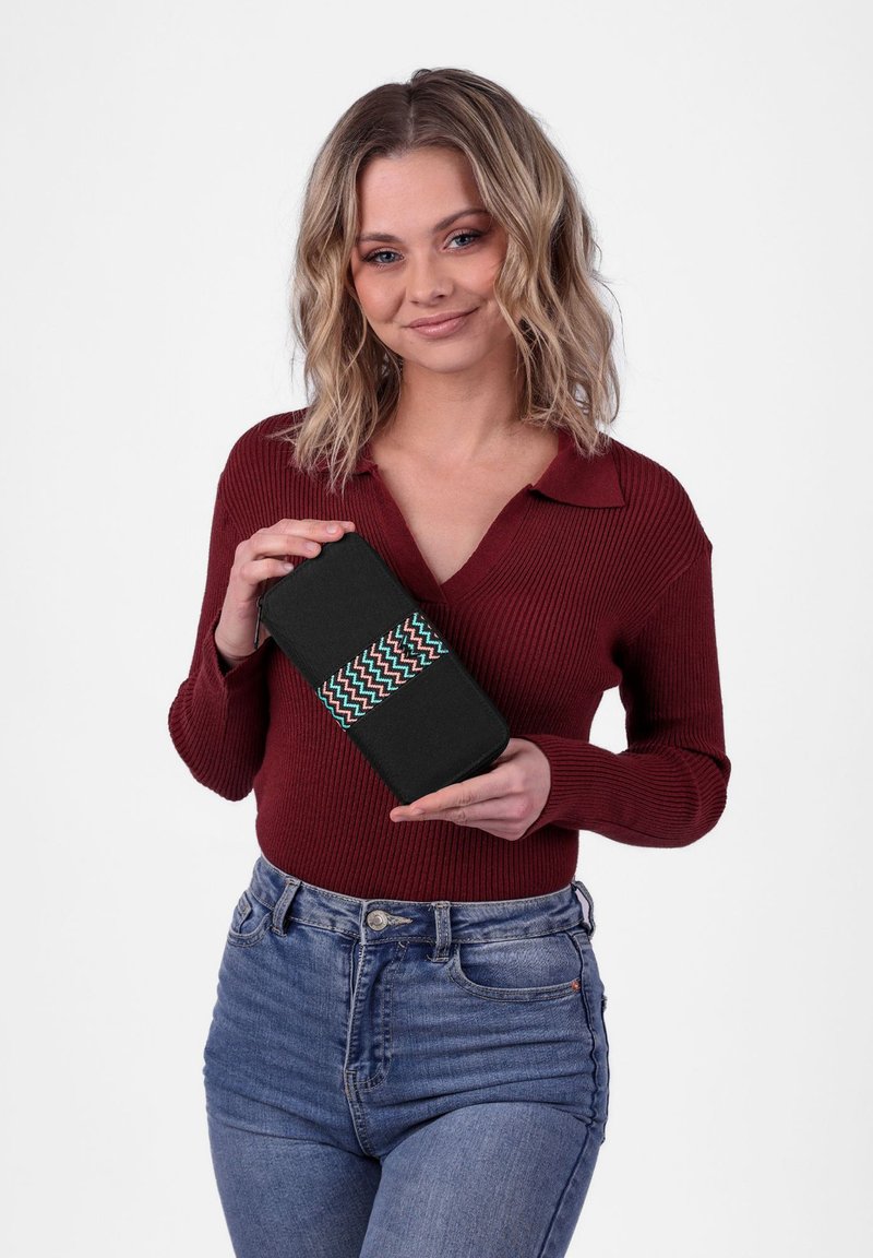 Black wallet with a woven green and red zigzag band. Designed with a rectangular shape and zip closure, it features a smooth fabric texture.