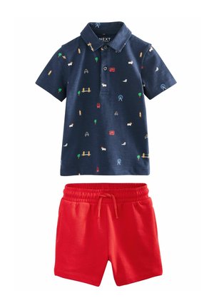 Marineblauwe polo met gekleurde gedrukte patronen; rode shorts met elastische taille. Katoenmengsel, korte mouwen, twee knoopsluitingen.