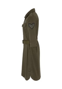 Abito verde oliva con colletto a camicia, chiusura anteriore con bottoni, maniche lunghe, cintura in vita e due tasche sul petto con insegne in stile militare.