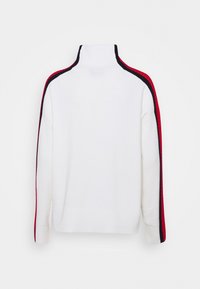 Biały sweter z golfem z czerwonymi i granatowymi paskami na ramionach i rękawach. Gładka tekstura, klasyczny krój i ściągacze przy mankietach.