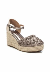 Alpargatas de cuña bordadas en bronce con punta redondeada, plataforma de yute y tira para el tobillo. Tejido texturizado y acentos metálicos.