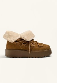 Rjave semiš gležnjarje z ovratnikom iz umetnega krzna, okroglo konico, debelim rjavim podplatom in vezalkami z teksturirano površino.