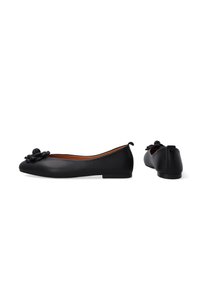 Schwarze Ballerinas aus glattem Leder mit runder Spitze. Mit einem floralem Akzent an der Vorderseite und einem kleinen Absatz. Das Innenfutter ist in Beige gehalten.