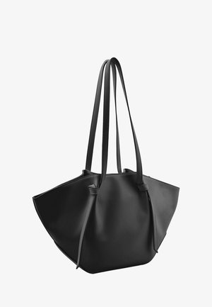 Black leather tote bag with wide open top and two long shoulder straps, showing smooth texture and minimalist design.