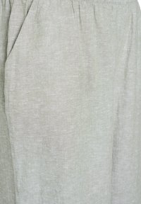 Svetlozeleno laneno oblačilo, ki se ponaša z mehko teksturo, nabranim pasom in stranskimi žepe za funkcionalnost.