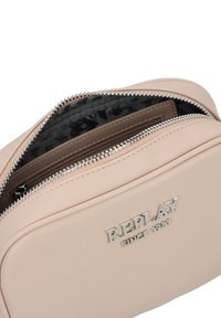 Borsa in similpelle rosa chiaro con chiusura in zip argentata e logo impresso 'REPLAY SINCE 1981'. Fodera interna testurizzata con pattern sottile.