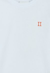 Hvit bomull t-skjorte med en oransje brodert "II" på venstre brystområde; klassisk rund hals, korte ermer, glatt tekstur.