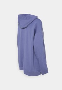 Sudadera con capucha de color púrpura claro, con un diseño suelto, dobladillo y puños acanalados, y una textura de tela suave. La vista trasera muestra el detalle de la capucha.