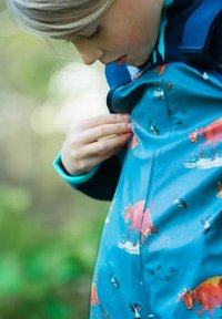 Vandtæt jakke i klar blå med et legende mønster af farmdyr, der viser røde køer og fugle, og har en glat, blank tekstur.