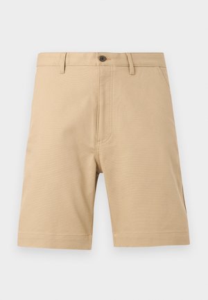 Beige men's knee-length shorts with belt loops, front pockets, button closure, and visible stitching details on plain background.