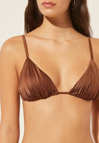 Brown triangle bikini top made of shiny fabric with pleated design. Features thin, adjustable straps and minimal hardware.