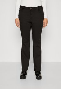 Jean noir avec une coupe droite, en denim, doté de matériel en métal et de poches avant. Assortis à des chaussures à plateforme noires brillantes.
